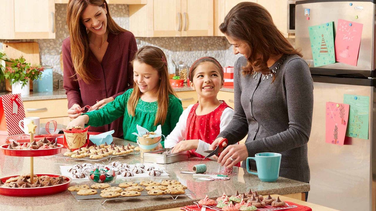 parents and children baking peanut butter blossoms in the kitchen