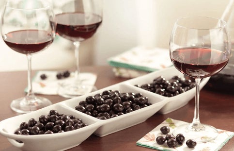 glasses of wine next to serving dish filled with brookside chocolate candies